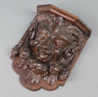 A carved oak bracket decorated a grotesque 22cm h x 17cm w x 8cm d 