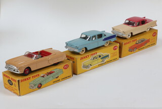 Dinky Toys, a 180 Packard Clipper Sedan with cerise upper body and cream lower body spun hubs dark yellow picture box and correct colour spot together with a 132 Packard Convertible tan body red hubs with dark yellow box and correct colour spot and a 179 Studebaker Presidential Sedan, light blue body with dark blue flash, cream wheels and hubs, dark yellow box with correct colour (chip to bonnet, white mark on roof)