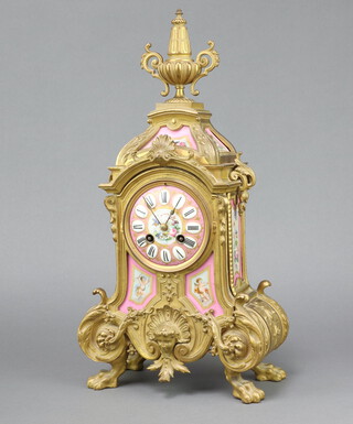 A 19th Century French 8 day timepiece contained in a gilt metal and pink porcelain case with Roman numerals, the case surmounted by a lidded urn, the back plate marked VR 90800355, complete with pendulum and key 