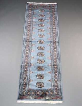 A blue, black and white ground Bokhara runner with 13 octagons to the centre within a multi row border 240cm x 80cm 