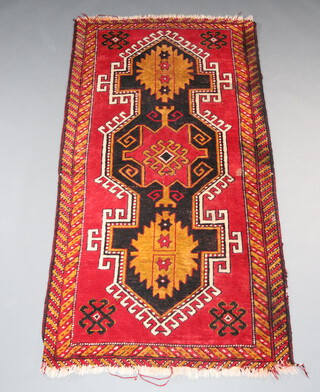 A red, orange, white and black ground Afghan rug with 3 stylised diamonds to the centre, 195cm x 103cm 