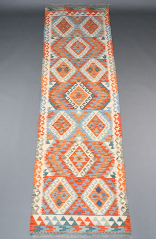 An orange white and green ground Chobi Kilim runner with all over geometric designs 295cm x 88cm 