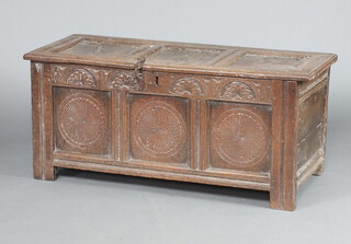 A mid 17th Century carved oak coffer of panelled construction with carved lunettes to the front panel, the top with old iron chain, the interior fitted a candle box 52cm h x 118cm w x 48cm d 