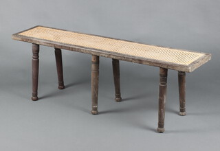 A 19th Century rectangular oak campaign stool with woven cane seat, raised on 6 detachable turned supports 44cm h x 133cm w x 28cm d  