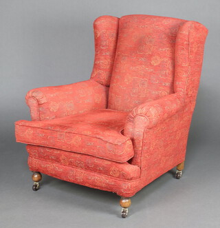 A Howard style winged armchair upholstered in red and gold material 89cm h x 81cm w x 88cm d (seat 34cm x 46cm)  