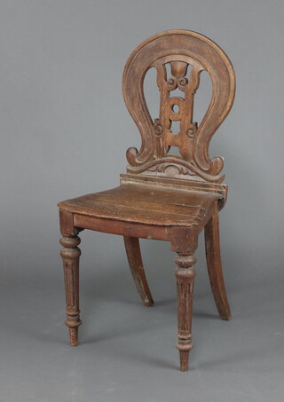 A Victorian pierced and carved oak hall chair with shaped back and seat, on turned supports 88cm h x 43cm w x 34cm d 