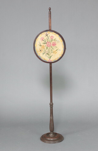 A Victorian mahogany pole screen with circular Berlin woolwork banner on a circular base 135cm h 