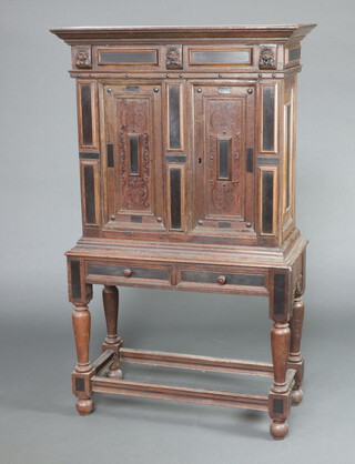 An 17th Century Dutch oak cabinet on stand, the upper section with moulded cornice enclosed by a panelled door, the (possibly later) base fitted 2 drawers, raised on turned supports 170cm h x 100cm w x 46cm d 