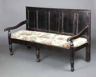 An 18th Century oak settle with raised back, the seat formed of iron straps, raised on turned supports 102cm h x 170cm w x 71cm d  