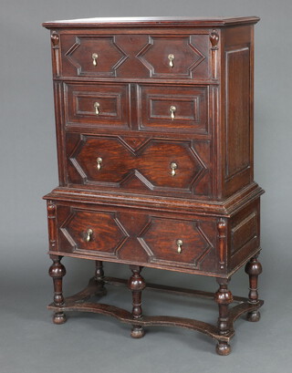 A Victorian Jacobean style oak chest on stand with geometric mouldings, the upper section fitted 3 drawers, the base fitted a drawer, raised on cup and cover supports with wavy stretcher 165cm h x 107cm w x 54cm d 