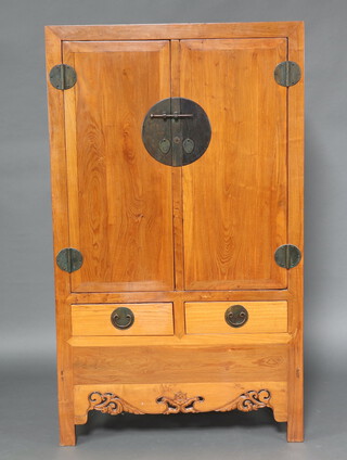 A 19th/20th Century Chinese hardwood cabinet, the interior fitted shelf and 2 drawers enclosed by a panelled door, the base fitted 2 drawers with carved and pierced apron 176cm h x 103cm w x 46cm d 