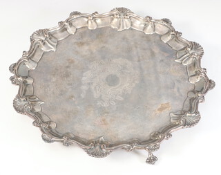 A Victorian silver salver with shell and scroll rim, raised on claw and ball feet with later engraved crest, London 1888, by Frederick Elkington, 563 grams, 27cm 