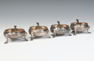 A set of 4 George III repousse silver table salts with vacant cartouches and floral decoration on hoof weight 1 hallmarked London 1769 and 4 later spoons, 169 grams  