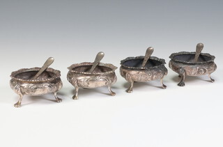 A set of 4 Victorian repousse silver table salts with floral decoration, shell knees and pad feet, London 1888, together with 4 Victorian spoons, maker Charles Stewart Harris, gross weight 212 grams 