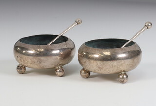 A pair of Victorian table salts on ball feet with spoons, Sheffield 1869, 83 grams 