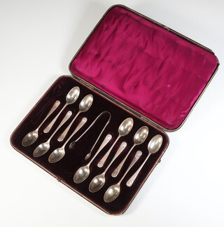 A set of 11 Victorian silver teaspoons with shell ends and tongs, London 1884, 162 grams, cased 