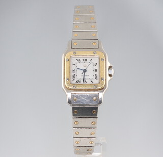 A lady's steel cased Cartier Santos de Cartier automatic wristwatch the dial with a gilt coronet with gilt mounted case 25mm on a steel bracelet with gilt mounts, numbered 090251 152 
