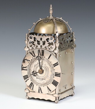 A Victorian silver cased lantern clock with pierced domed top and brass bell the circular chapter ring with Roman numerals, engraved floral centre, raised on ball feet, inscribed on the back "I serve ye here wythe all my myghte to tell ye hours by daye and nyghte, therefore example take by me and serve thy God as I serve ye", Edinburgh 1887, maker AC, 21cm  