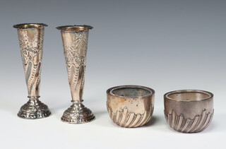 A pair of Victorian silver repousse scroll demi fluted bowls containing clear glass liners, London 1867, 4cm, together with a pair of repousse silver spill vases weighted, London 1883, 11cm, weighable silver 70 grams 