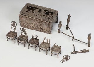 A Dutch white metal repousse miniature dining table with a hinged lid decorated with cavorting cherubs, together with 5 dining chairs, 250 grams  