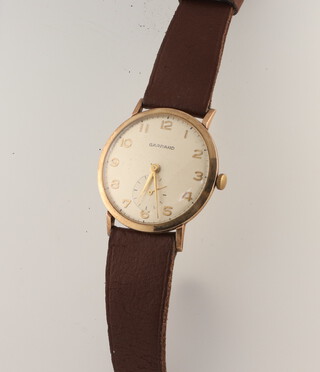 A gentleman's yellow metal Garrards wristwatch with seconds at 6 o'clock contained in a 35mm case number 23511, on a leather strap 