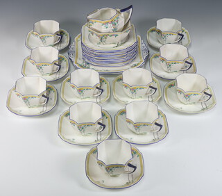 An Art Deco Shelley part tea set no.11624 decorated with birds beneath flowering trees comprising 12 tea cups (5 a/f), 11 saucers (2 a/f), 12 tea plates (1 a/f), 2 cake plates (both a/f), a jug, sugar bowl (a/f), together with a tablecloth and napkins 