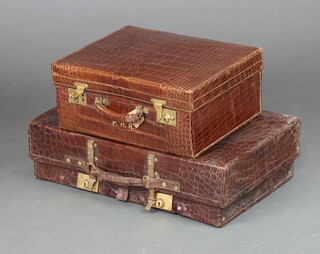 The Revelation, a crocodile suitcase with gilt metal locks 17cm h x 65cm w x 38cm d, together with a crocodile vanity case with hinged lid and fall front, gilt locks 20cm h x 46cm w x 35cm d 
