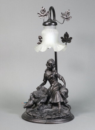 A bronzed table lamp in the form of a seated girl with sheaths of corn and geese, with glass trumpet shaped shade 43cm h 