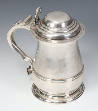 A good George II silver lidded tankard of bulbous form, strap work decoration and S scroll handle, having a pierced thumb piece, the handle engraved OFS, London 1747, maker Richard Gurney and Co, 699 grams, 19cm    