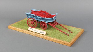 A scratch built 1893 Devon wagon displayed on a wooden plinth with grass diorama, the wagon 22cm l x 8cm w  