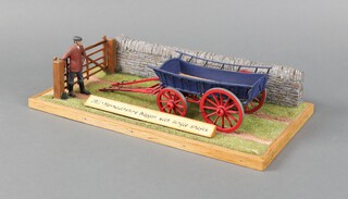 A scratch built 1911 Monmouthshire wagon displayed on a wooden plinth with fence, stone wall and grass diorama, the wagon 22cm l x 7cm w   
 