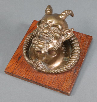 A cast gilt metal bust of a satyr marked J E B 1873, raised on an oak plaque 14cm x 15cm 