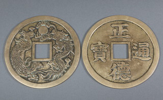 A pair of reproduction bronze Chinese charms decorated with dragons chasing the flaming pearl and symbols 