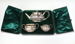 A Victorian silver 3 piece demi-fluted tea set with ebony handle, the teapot London 1893, the milk jug and sugar bowl Birmingham 1892, gross weight 855 grams, in original fitted case 