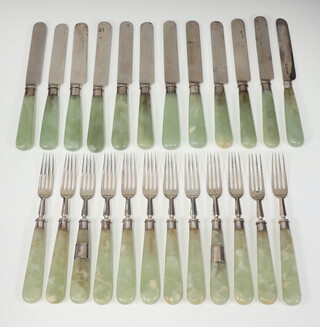 A set of Edwardian cutlery comprising 12 dessert forks with Edwardian silver prongs London 1906 and 12 dessert knives, 11 with plated blades and hardstone handles and one with a silver blade London 1878 (3 forks repaired) 