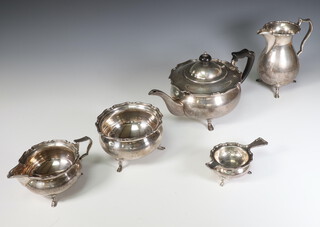 A 5 piece silver tea set with shaped rims, the teapot with ebony handle and finial Sheffield 1915 together with a matching milk jug, cream jug, sugar bowl, tea strainer and stand, Sheffield 1962, gross weight 1846 grams 