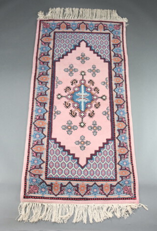 A pink and blue ground Afghan rug with stylised medallions to the centre 207cm x 100cm 