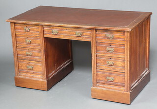 A Victorian oak desk with brown inset writing surface above 1 long and 8 short drawers with brass drop handles 76cm h x 132cm w x 69cm w  