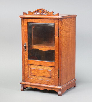 A light oak smokers cabinet fitted a drawer enclosed by bevelled plate panelled door on shaped supports 42cm x 23cm x 19cm 