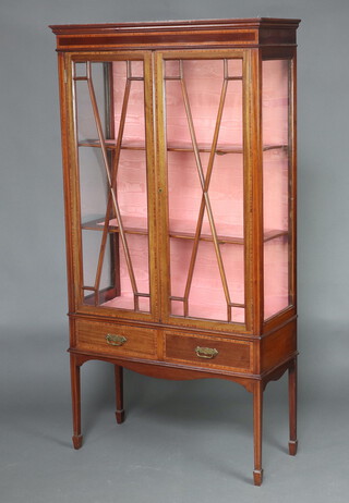 An Edwardian inlaid mahogany bookcase with moulded cornice, fitted shelves enclosed by astragal glazed panelled doors, the base fitted 2 drawers, raised on square tapered supports, spade feet 172cm h x 89cm w x 36cm d 