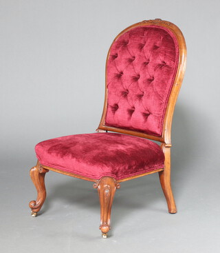 A Victorian carved mahogany show frame nursing chair upholstered in red buttoned material, raised on cabriole supports 91cm h x 51cm w x 47cm d 