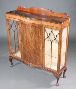 A 1930's Chippendale style mahogany bow front display cabinet with raised back, cupboard enclosed by a panelled door flanked by cupboards enclosed by astragal glazed doors, raised on cabriole supports 133cm h x 120cm w x 41cm d 