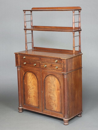 A Regency mahogany chiffonier, the raised back fitted 2 shelves, the base fitted a drawer with writing slope above 2 short drawers and cupboard enclosed by arched panelled doors, with turned columns to the side 146cm h x 85cm w x 39cm d 