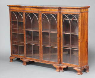 A 19th Century mahogany triple breakfront bookcase fitted shelves enclosed by arch shaped astragal glazed doors raised on ogee bracket feet 122cm h x 183cm w x 36cm d  