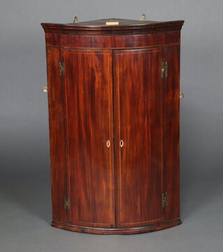 A Georgian inlaid mahogany bow front corner cabinet, shelved interior enclosed by panelled doors 105cm h x 68cm w x 47cm d  