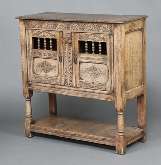 A reproduction 17th Century Ipswich style carved hutch cabinet enclosed by a panelled door with undertier, raised on turned and block supports 92cm h x 92cm w x 37cm d 