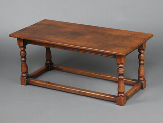 A rectangular oak coffee table raised on turned and block supports with box framed stretcher 45cm h x 106cm w x 51cm d 