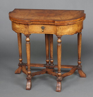 Gil and Reigate of London, a Queen Anne style figured walnut card table of crescent form, fitted a drawer, raised on octagonal turned supports with shaped stretcher 72cm x 76cm w x 38cm d 