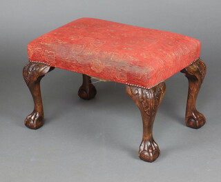 A Queen Anne style carved oak stool, on cabriole, claw and ball supports, seat upholstered in red and gold material 40cm h x 61cm w x 40cm d 