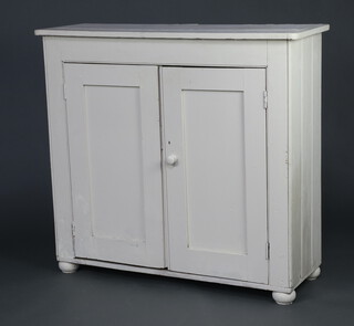 A 19th Century white painted pine cabinet with shelved interior enclosed by a pair of panelled doors 105cm h x 112cm w x 41cm d  